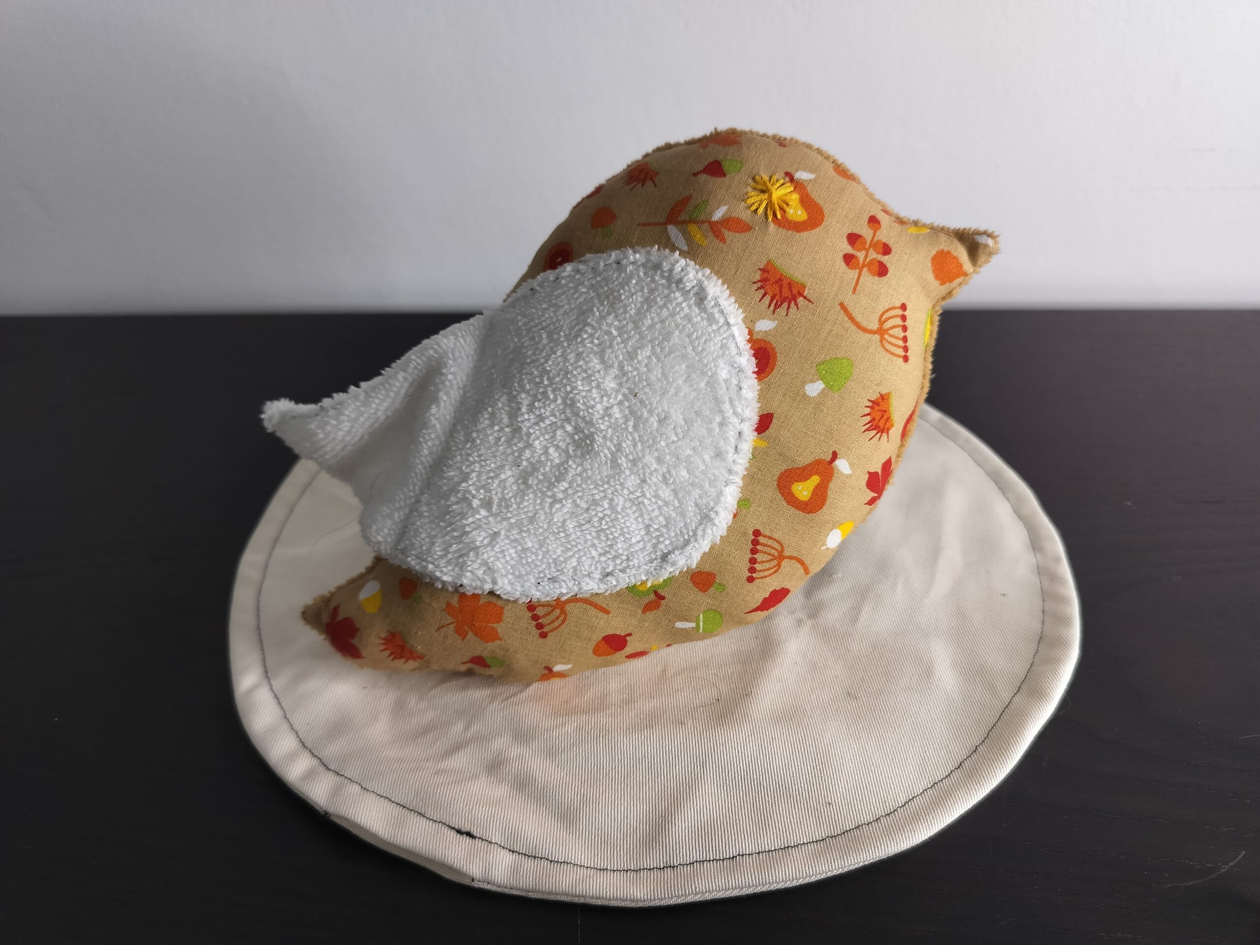 Peluche oiseau aux motifs d'automne avec une aile blanche en éponge et un œil brodé en forme d'étoile jaune.