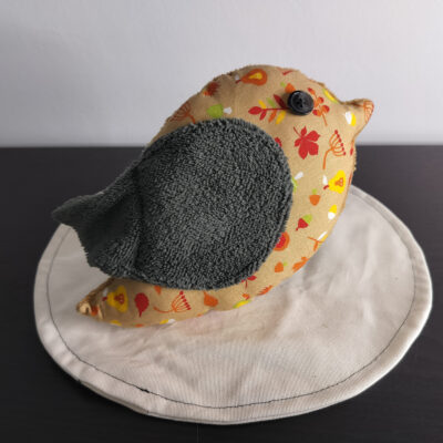 Peluche oiseau aux motifs d'automne avec une aile gris anthracite en éponge et un œil bouton noir.