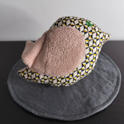 Peluche oiseau à motifs géométriques avec une aile en éponge vieux rose et un œil étoile vert brodé main.
