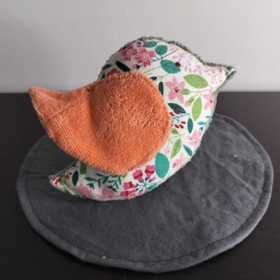 Peluche oiseau à motifs floraux avec une aile en éponge orange.