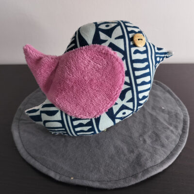 Oiseau décoratif en tissu wax bleu avec une aile en éponge rose et un œil bouton en bois.