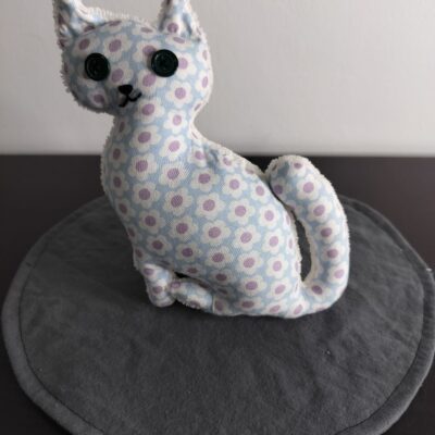 Peluche chat bleu ciel a petites fleurs blanches et violettes yeux boutons noirs envers eponge creme fait main