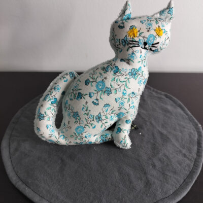 Peluche chat coton blanc a motifs de fleurs bleues et turquoise style Liberty yeux etoiles brodees jaunes envers eponge blanche fait main