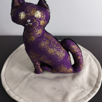 Peluche chat violet pourpre a motifs rosaces fleurs dorées style japonais yeux etoiles brodees beige envers eponge noire