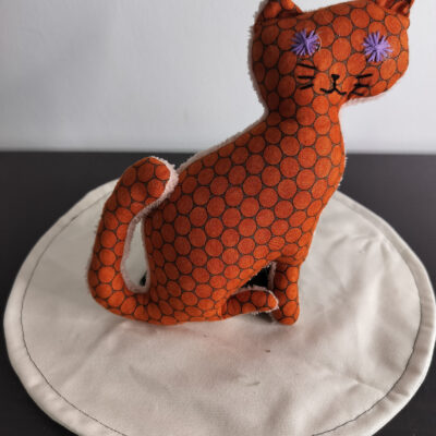 Peluche chat couleur terracotta orange brique a motifs alveoles noires yeux etoiles brodes violettes envers eponge creme fait main