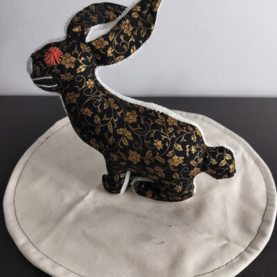 Peluche lapin noir motifs fleurs dorees envers eponge creme oeil brode rouge securite enfant