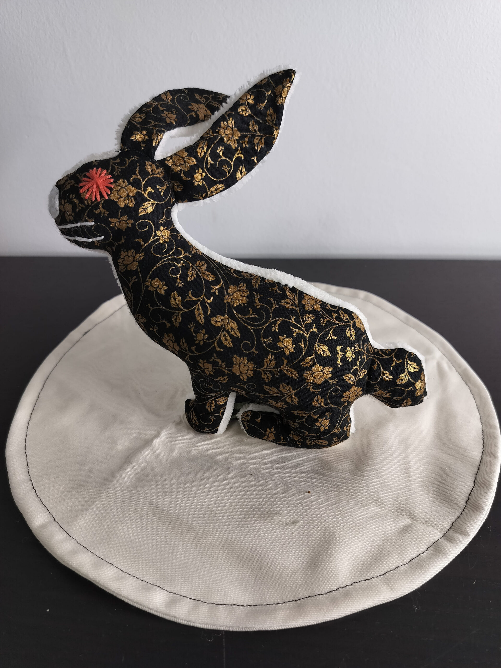 Peluche lapin noir motifs fleurs dorees envers eponge creme oeil brode rouge securite enfant
