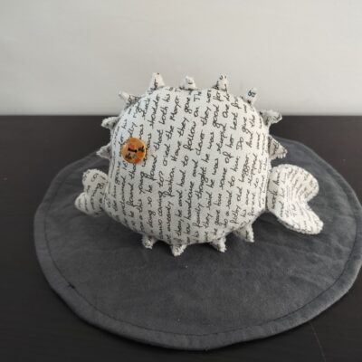 Peluche poisson globe en tissu blanc creme motif ecriture cursive manuscrite noire oeil bouton bois piques eponge fait main