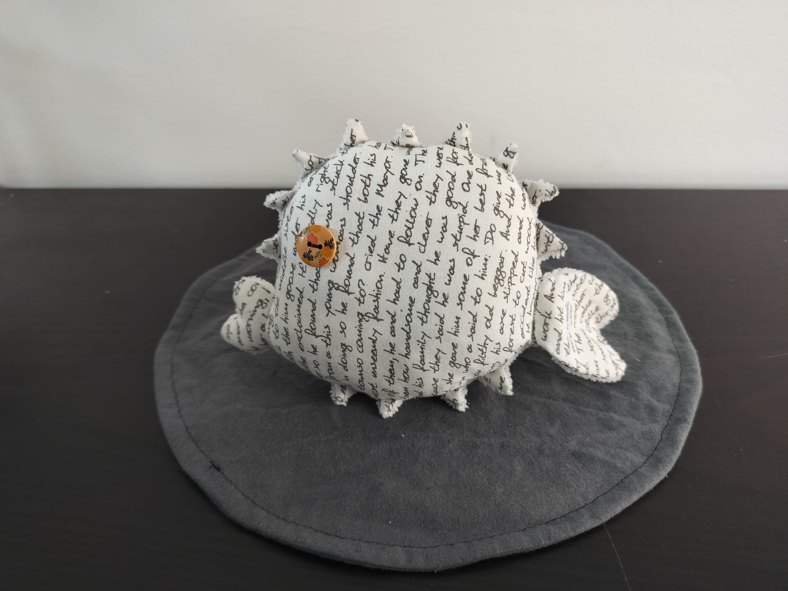 Peluche poisson globe en tissu blanc creme motif ecriture cursive manuscrite noire oeil bouton bois piques eponge fait main