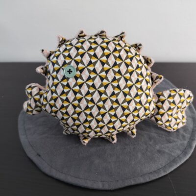 Peluche poisson globe geometrique en tissu a motifs triangles noir moutarde et rose oeil bouton vert d eau texture peluche rose poudre fait main
