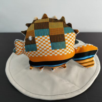 Peluche poisson globe Cameroun en tissu ethnique orange noir et bleu oeil etoile brode blanc texture peluche blanc creme fait main
