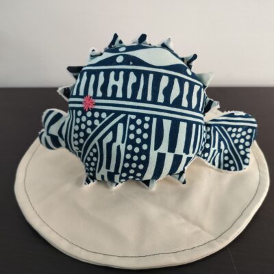 Peluche poisson globe Cameroun fait main en tissu traditionnel Ndop bleu indigo et blanc creme oeil etoile brode rose fuchsia et pointes en texture peluche