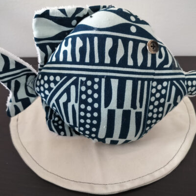 Peluche poisson rond de la collection Cameroun en tissu Wax bleu indigo et blanc avec un œil bouton marron rétro.