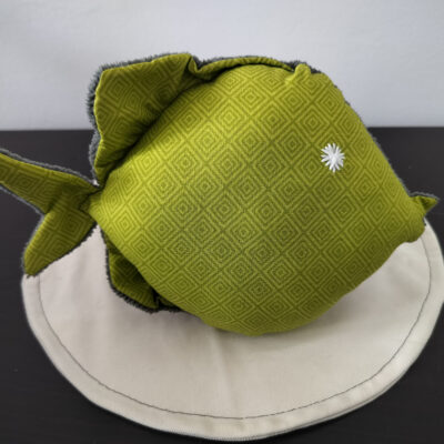 Peluche poisson rond au tissu vert anis à motifs de losanges géométriques avec un œil étoile blanc brodé main.