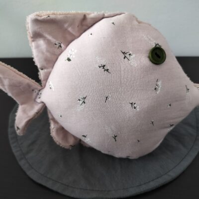 Peluche poisson rond au tissu vieux rose à motifs de brins de muguet avec un œil bouton vert olive.
