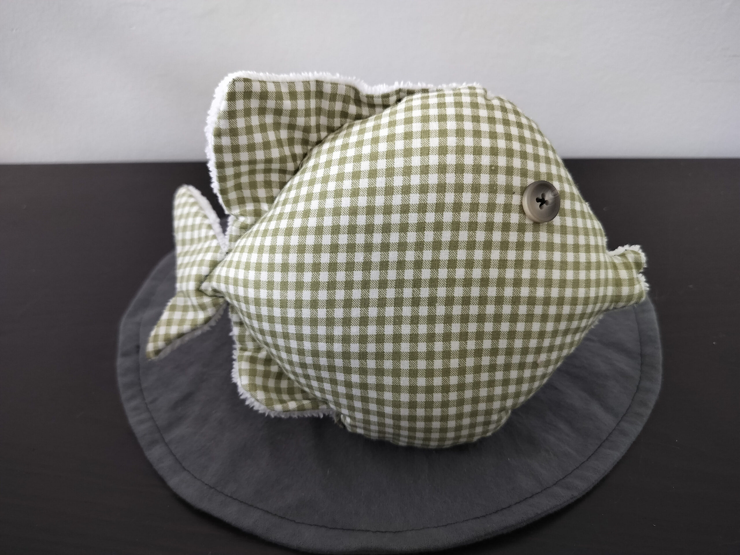 Peluche poisson rond au tissu à carreaux vichy vert olive et blanc avec un œil bouton beige satiné.