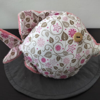 Peluche poisson rond au tissu fleuri blanc et rose avec un œil bouton en bois gravé vintage, création artisanale française.