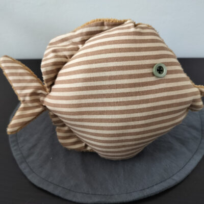 Peluche poisson rond rayé beige et blanc avec un œil bouton vert sauge rétro, cousu main en France.