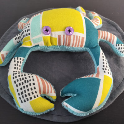 Peluche crabe artisanale vert et bleu avec motifs graphiques