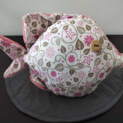 Peluche poisson rond fleuri, finition Bouton et tissu éponge rose poudré.