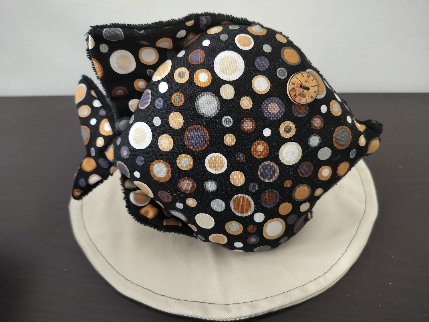 Peluche poisson rond pois graphiques, finition Bouton et tissu éponge noir.