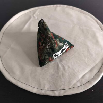 Bouillotte sèche feuillage de Noël, berlingot en tissu artisanal aux motifs de feuillage vert, baies rouges et baies blanches.