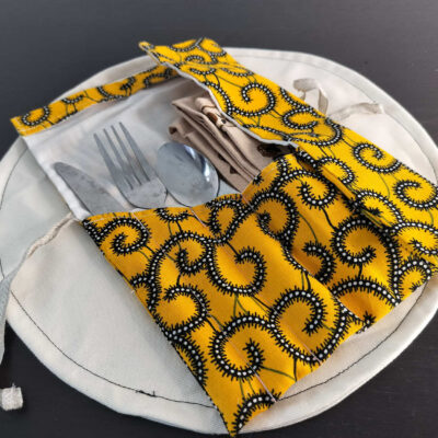 Étui Wax jaune et noir à motifs de spirales ethniques, pochette nomade nouée par un lien en lin.