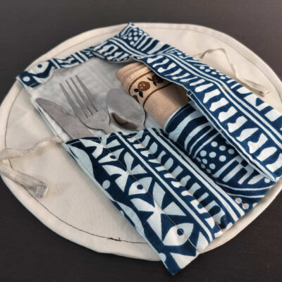 Étui multi-usages Wax bleu et blanc à motifs géométriques et tribaux, pochette nomade nouée par un lien en lin.