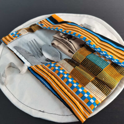 Étui Wax orange vif et turquoise à motifs géométriques, pochette nomade nouée par un lien en lin.