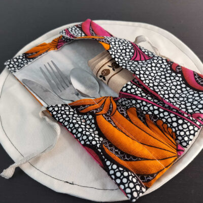 Étui Wax rose fuchsia et noir à grands motifs floraux, pochette nomade nouée par un lien en lin.