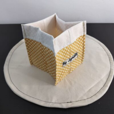 Vide-poche en tissu poudré et délicat, petit panier carré bicolore avec revers blanc un coton jaune moutarde parsemé de petits pois blancs.