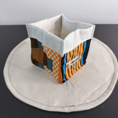 Vide-poche en tissu wax orange, petit panier carré bicolore avec revers blanc un tissu Wax aux nuances chaleureuses d'orange, de bleu et de noir, aux motifs géométriques et damiers.