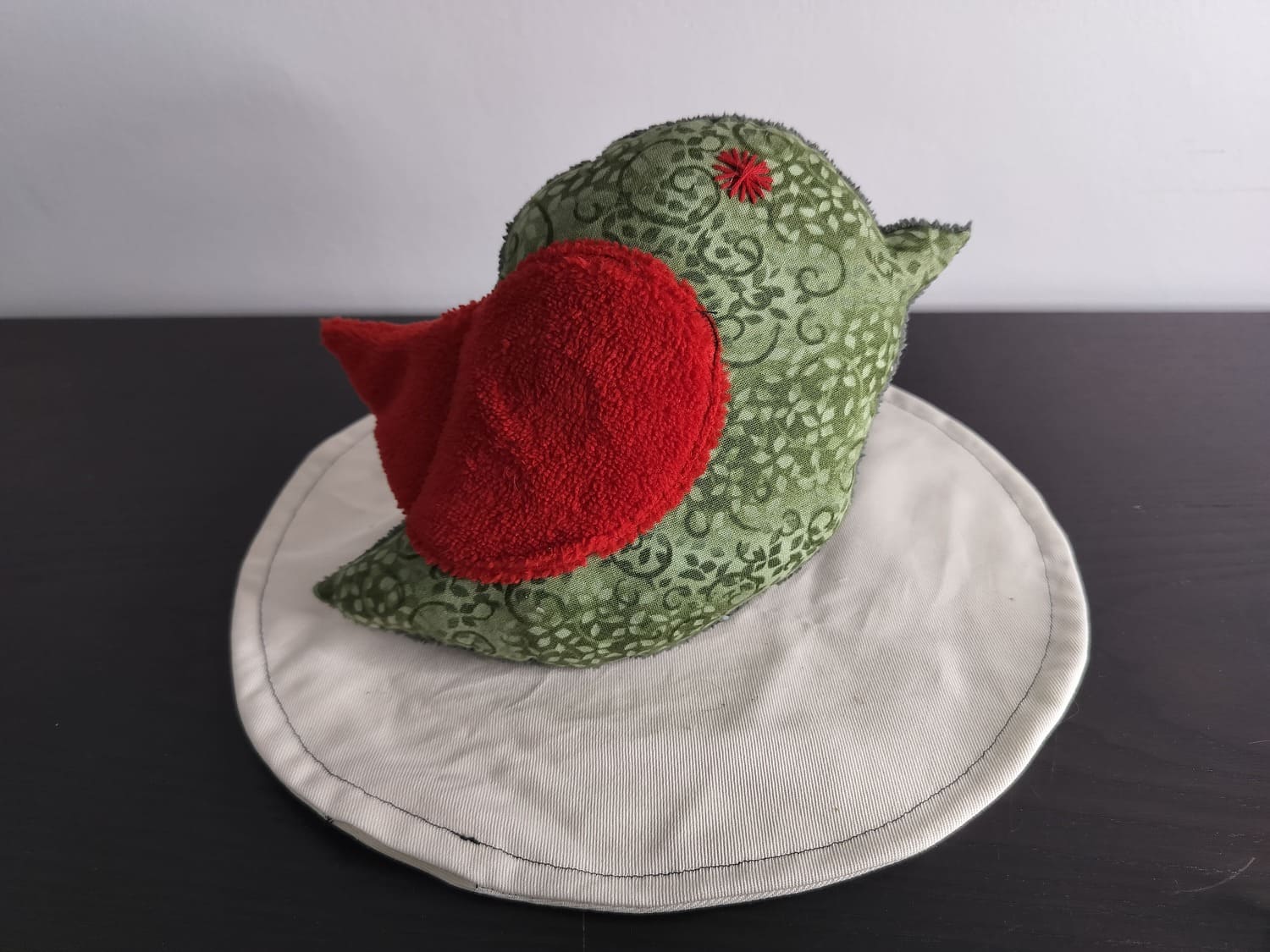 Peluche oiseau vert, finition Brodé et tissu éponge rouge.