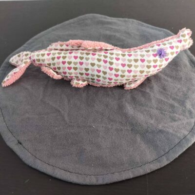 Peluche sardine petits cœurs graphiques, avec yeux brodés violet et tissu éponge rose.