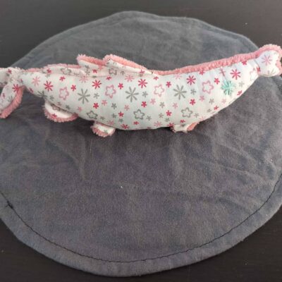 Peluche sardine fleurs et étoiles d'hiver, avec yeux brodés bleu clair et tissu éponge rose poudré.