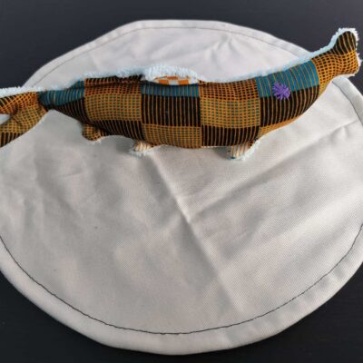 Peluche sardine wax orange, avec yeux brodés violet et tissu éponge blanc écru.